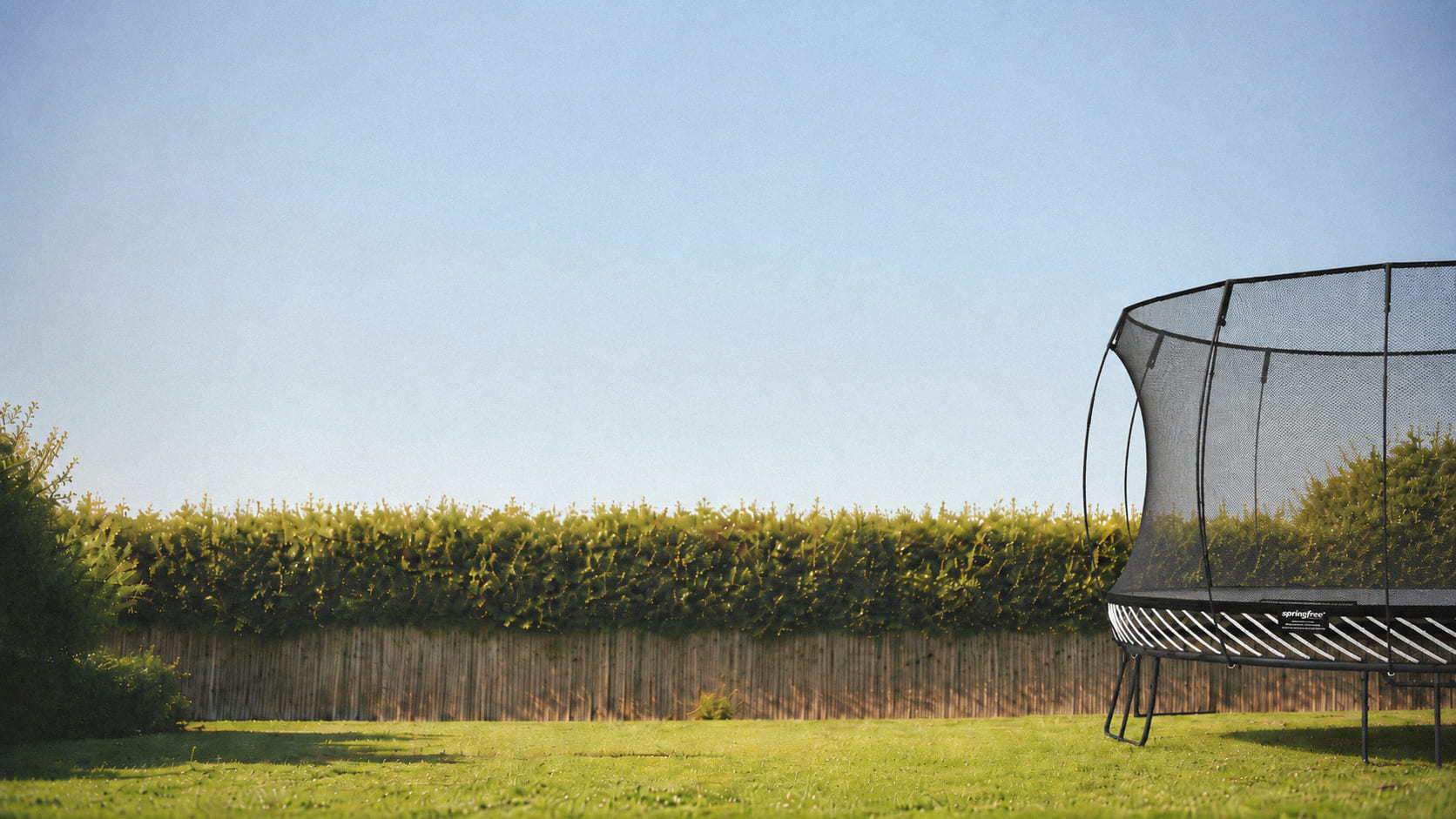 Springfree trampoline on a green lawn in an Auckland backyard