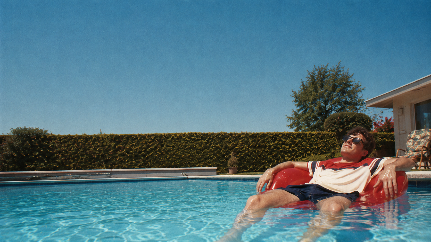 Man relaxing in a swimming pool on a sunny day